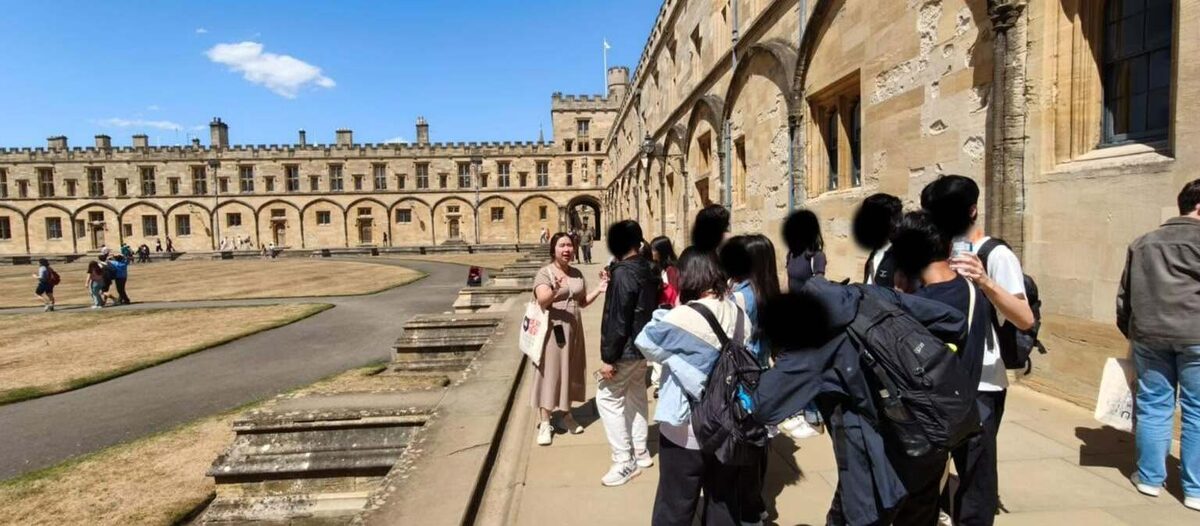 A group listening to their guide in Tom Quad at Christ Church, Oxford
